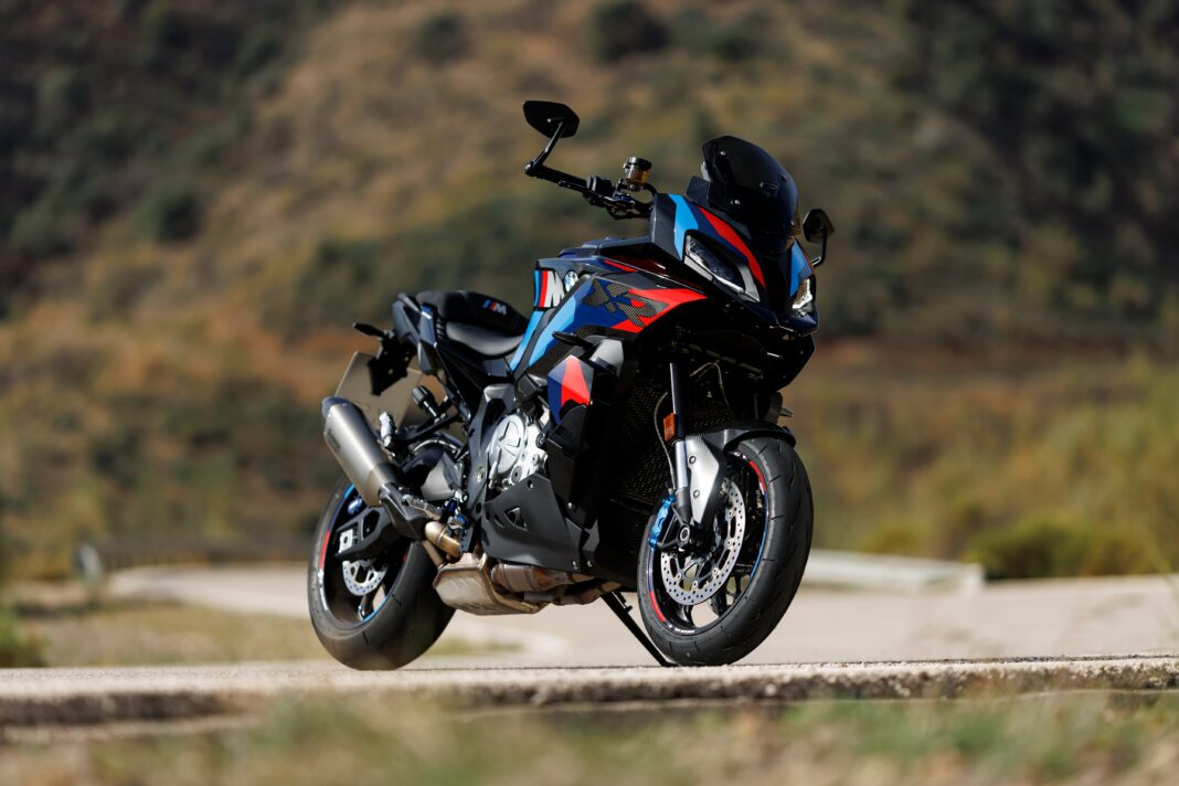 BMW M 1000 XR en vista lateral, moto deportiva crossover color blanco y rojo con alerones
