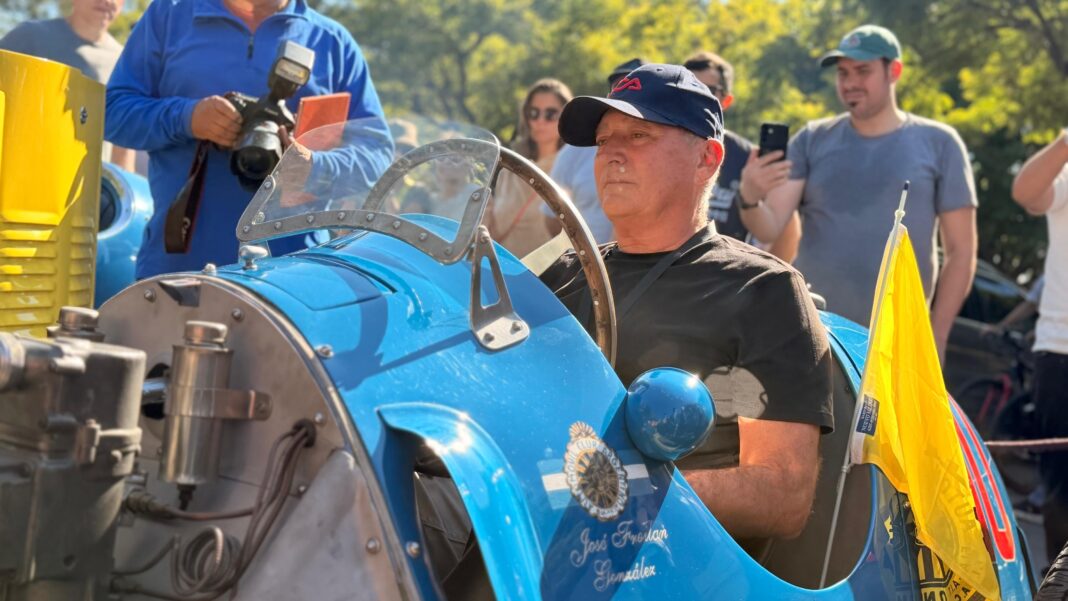 Autos clásicos en carrera en avenidas de Buenos Aires, con sobrino de Juan Manuel Fangio y una Ferrari histórica.