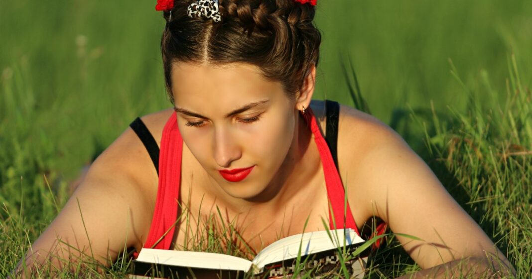 Persona leyendo un libro abierto en un entorno tranquilo