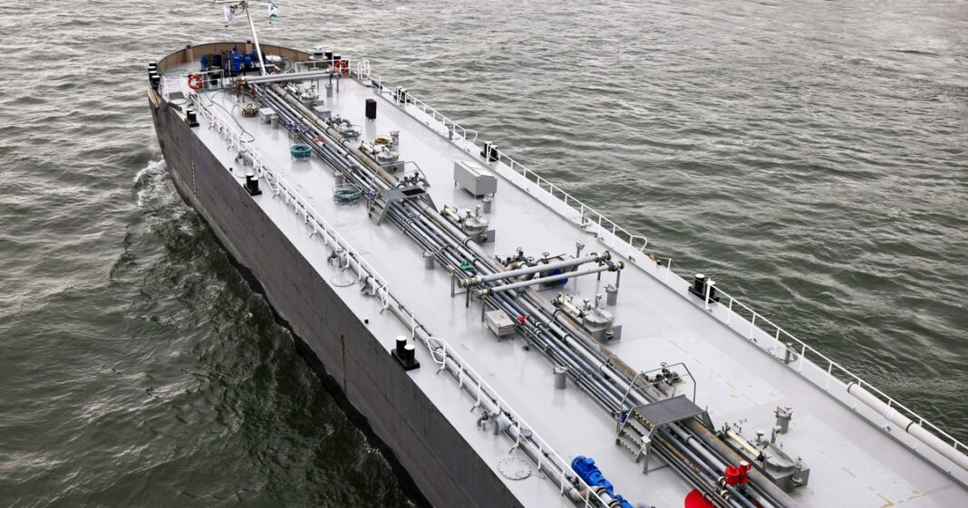 Gráfico que muestra la caída en la producción mundial de petróleo y un barco petrolero cerca del estrecho de Ormuz.