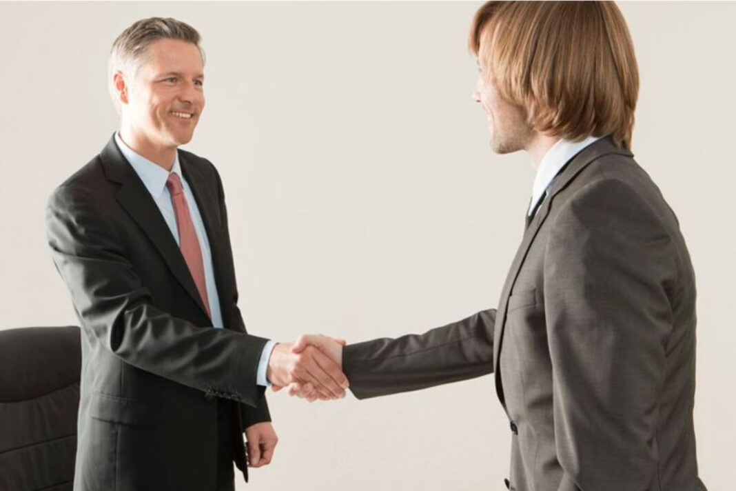 Logo de la Real Academia Española (RAE) junto a un globo terráqueo que representa el uso del español en el mundo.