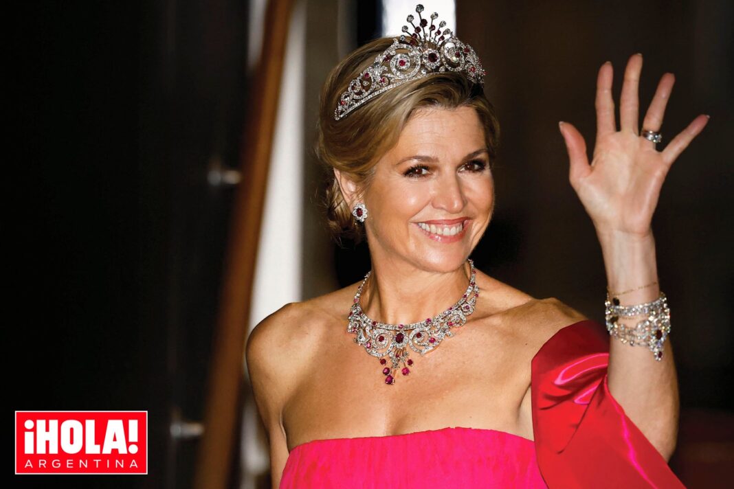 Reina Máxima con vestido strapless fucsia y rojo y tiara del Pavo Real en recepción diplomática