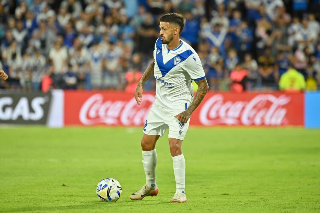 Escudos de Vélez Sarsfield y Gimnasia de Mendoza separados por un balón de fútbol.