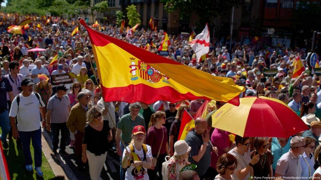 Manifestantes con banderas españolas en una calle de Madrid durante la protesta contra Pedro Sánchez