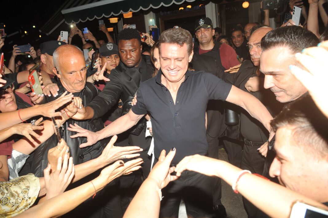 Luis Miguel cantando en un concierto con micrófono en mano