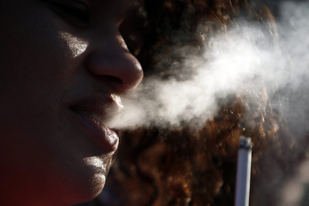 Cigarrillos en un cenicero con humo, representando el consumo de tabaco
