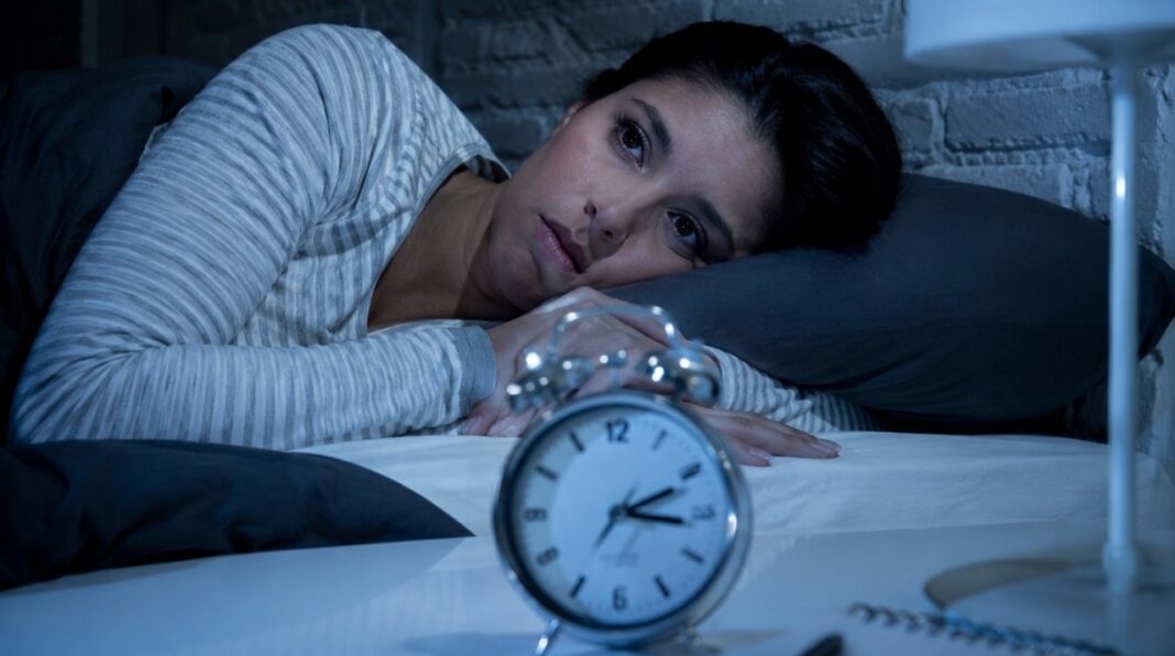 Persona durmiendo en una cama en una habitación oscura
