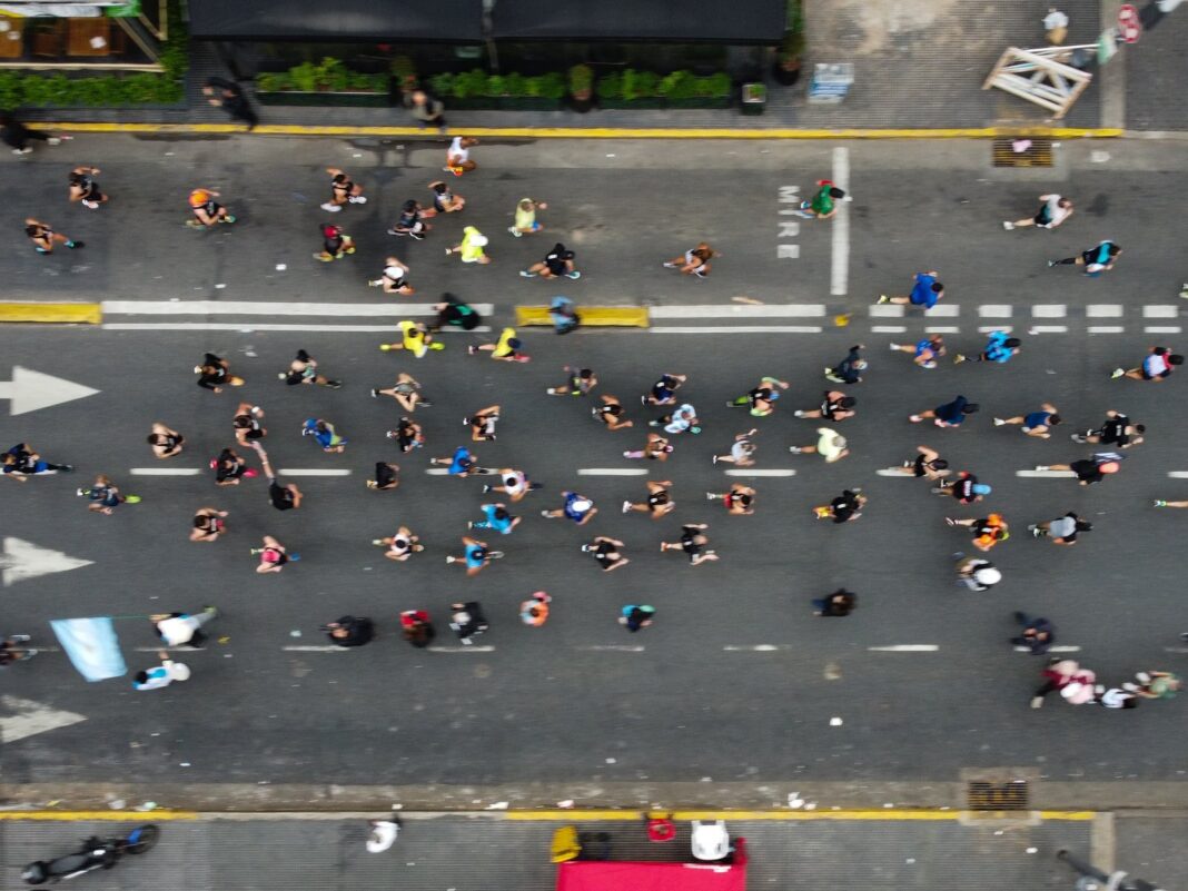 Personas corriendo en una plaza de Buenos Aires durante una carrera dominical