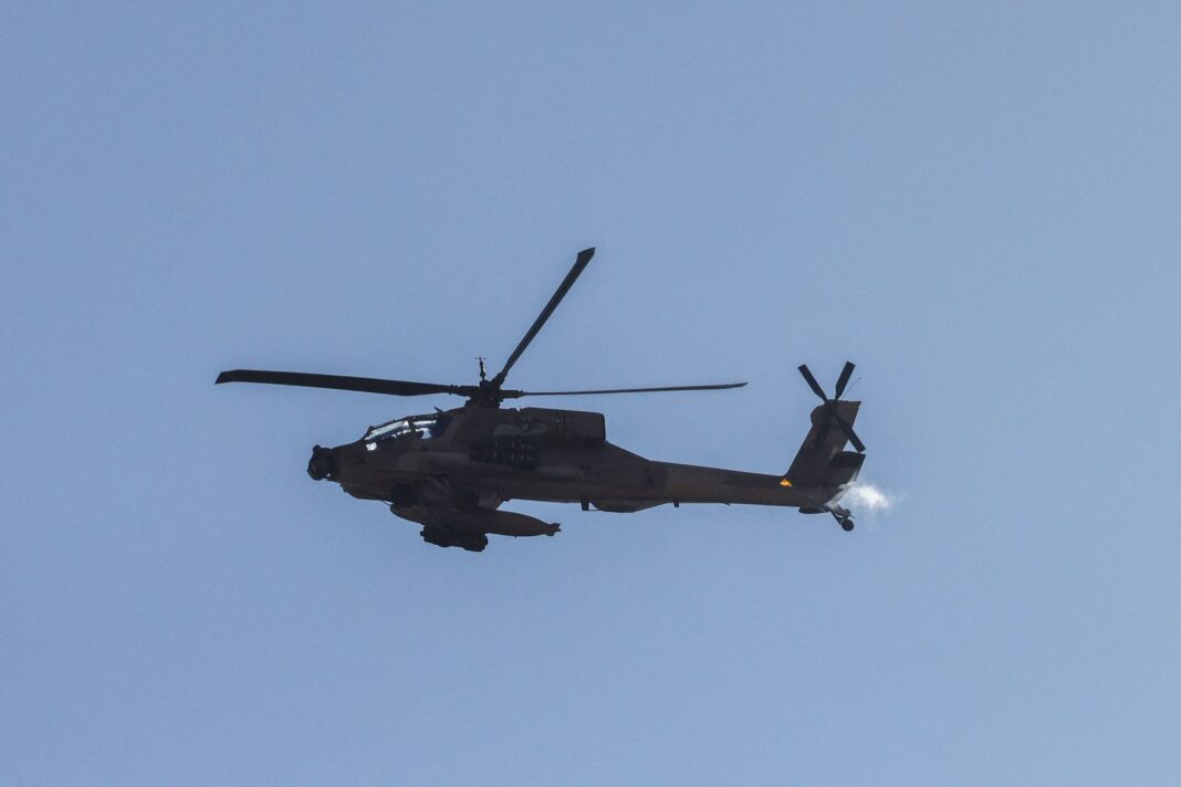 Helicóptero militar Apache de Estados Unidos sobrevolando una zona desértica