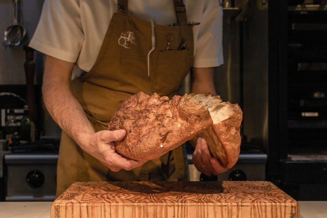 Pan de masa madre recién horneado sobre una tabla de madera