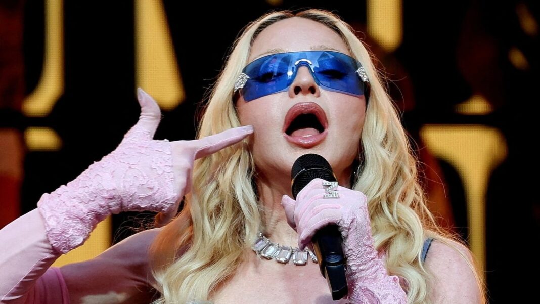 Madonna sosteniendo el álbum Confessions II