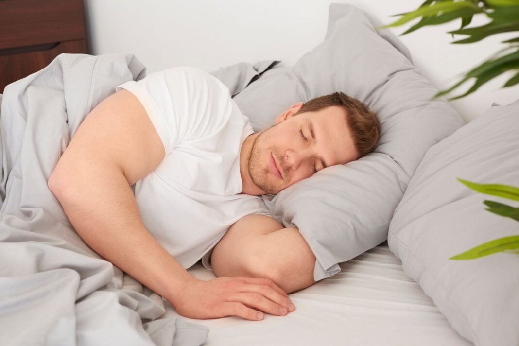 Persona durmiendo en una cama con expresión serena, representando el acto de soñar con familiares