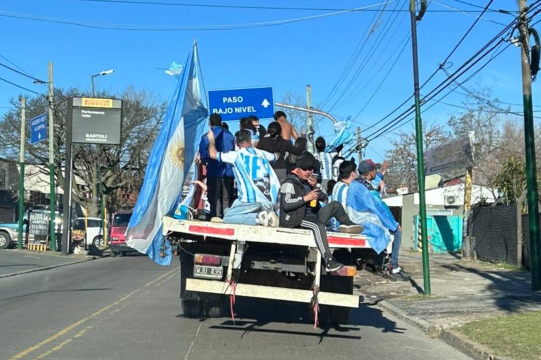 Hinchas argentinos festejando en las calles de Buenos Aires con banderas celestes y blancas