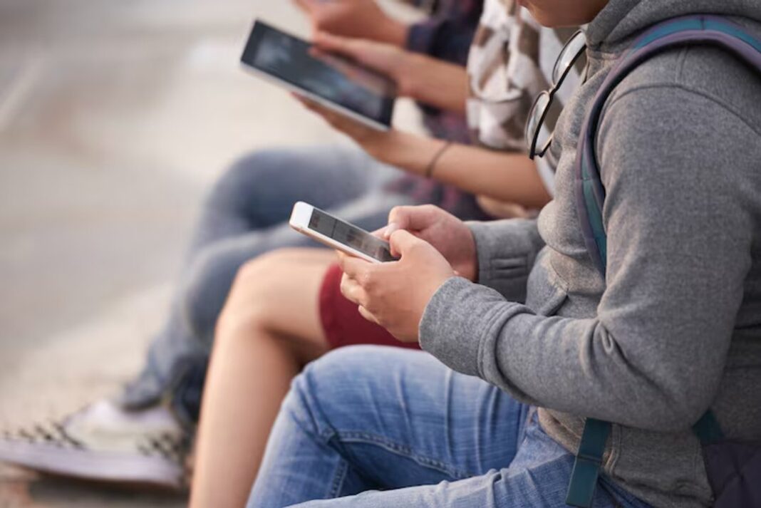 Jóvenes usando redes sociales en un dispositivo móvil