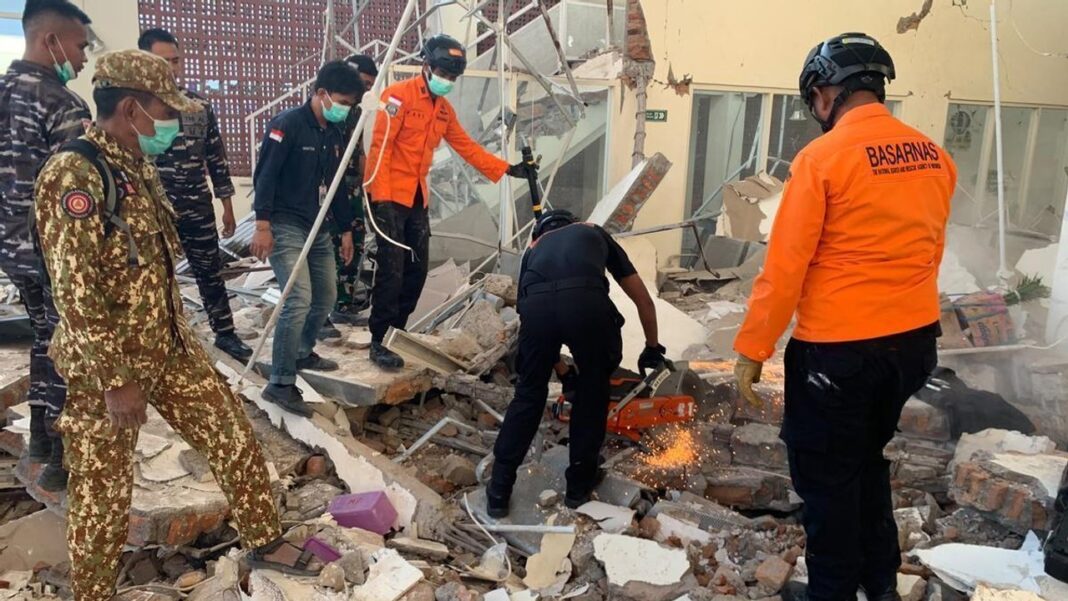 Rescatistas buscan sobrevivientes entre los escombros en la localidad de Maumere, Indonesia