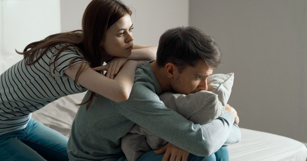 Pareja joven conversando en un sillón
